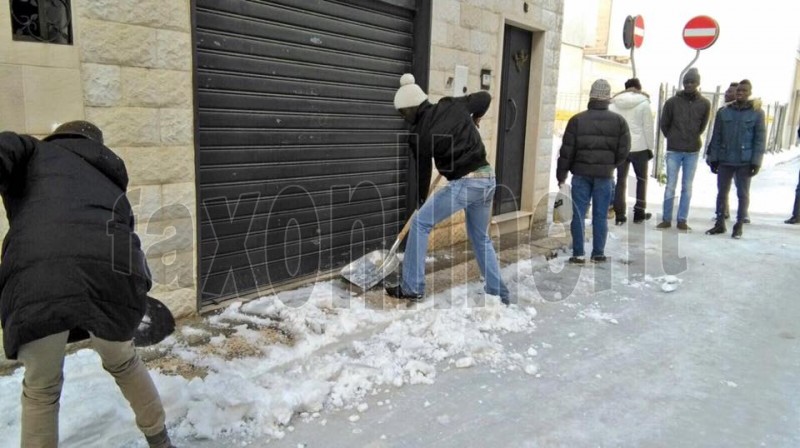 migranti spala neve